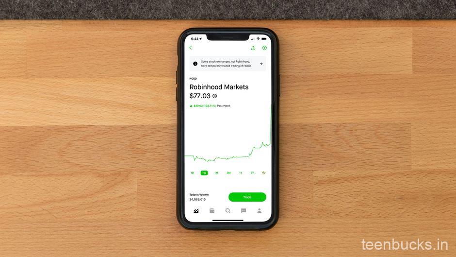 Smartphone on student study desk showing trading alerts and stock market notifications
